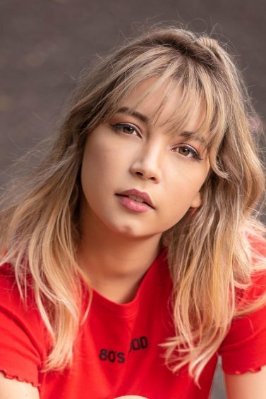 mulher com cabelo loiro longo, liso e franja