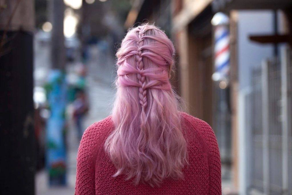 Mulher com cabelo rosa longo com penteado de trança semipreso