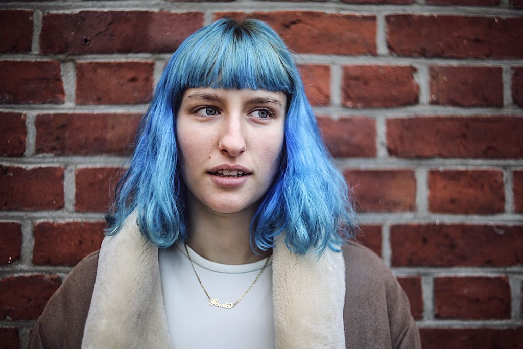 Mulher com cabelo azul de comprimento médio e franja