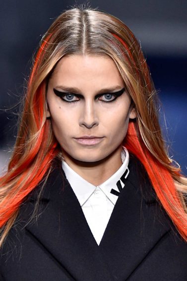 Modelo loira com mechas laranjas para matéria sobre a tendência das mechas coloridas