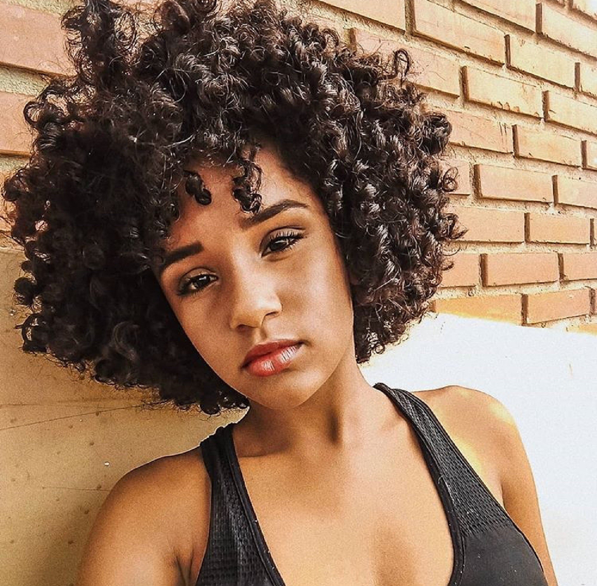 Mulher com cabelos curtos cacheados
