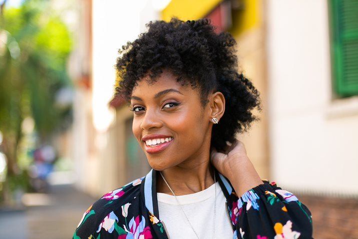 Mulher com cabelo cacheado semipreso com franja
