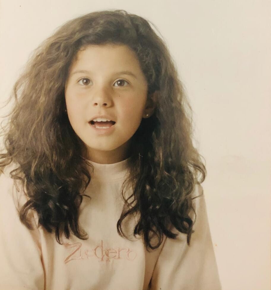 menina com cabelo longo cacheado surpresa