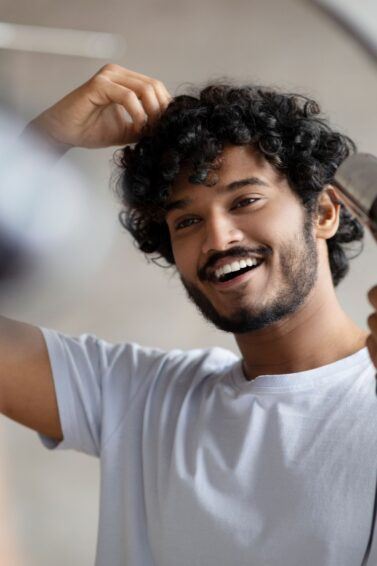 homem com o cabelo cacheado natural