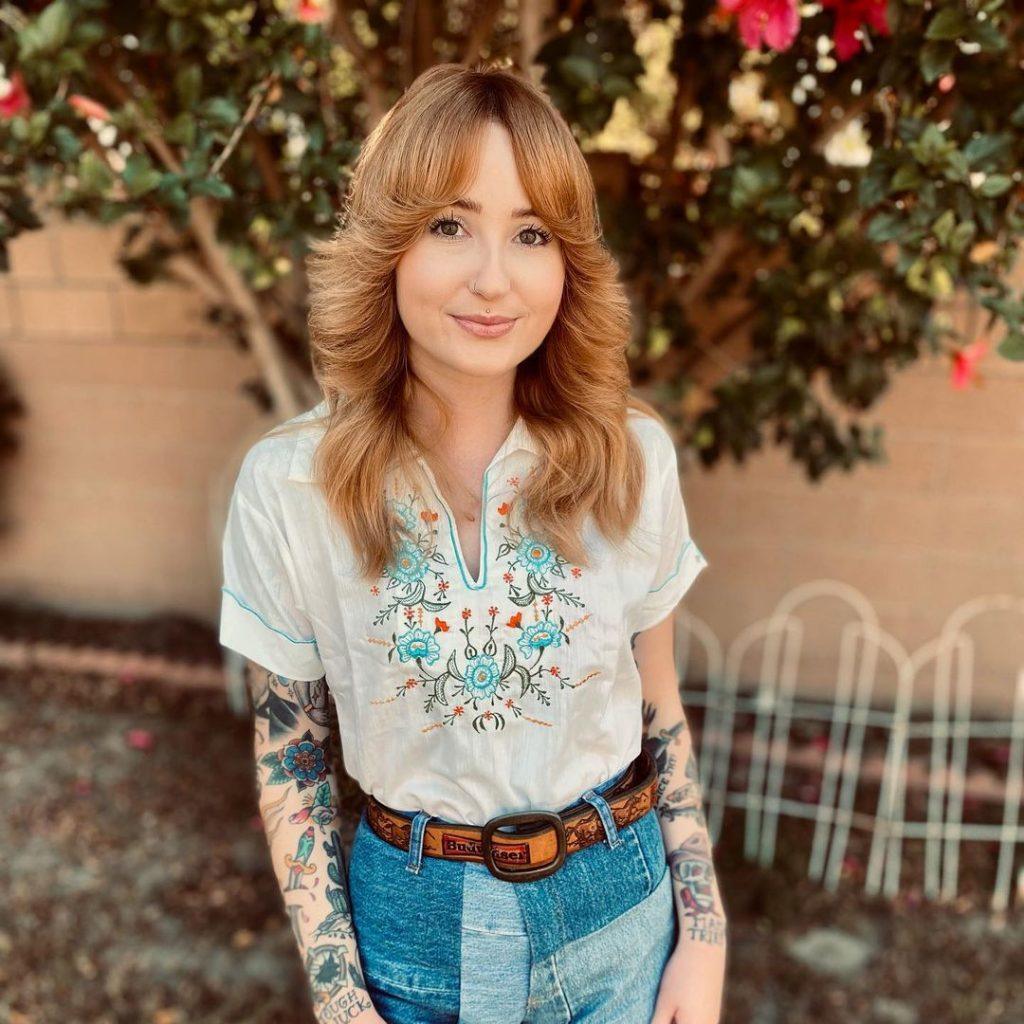 mulher com o cabelo longo estilo farrah fawcett