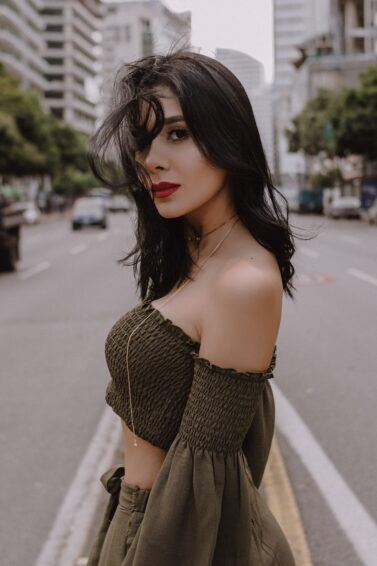 mulher de lado com batom vermelho e cabelo escuro
