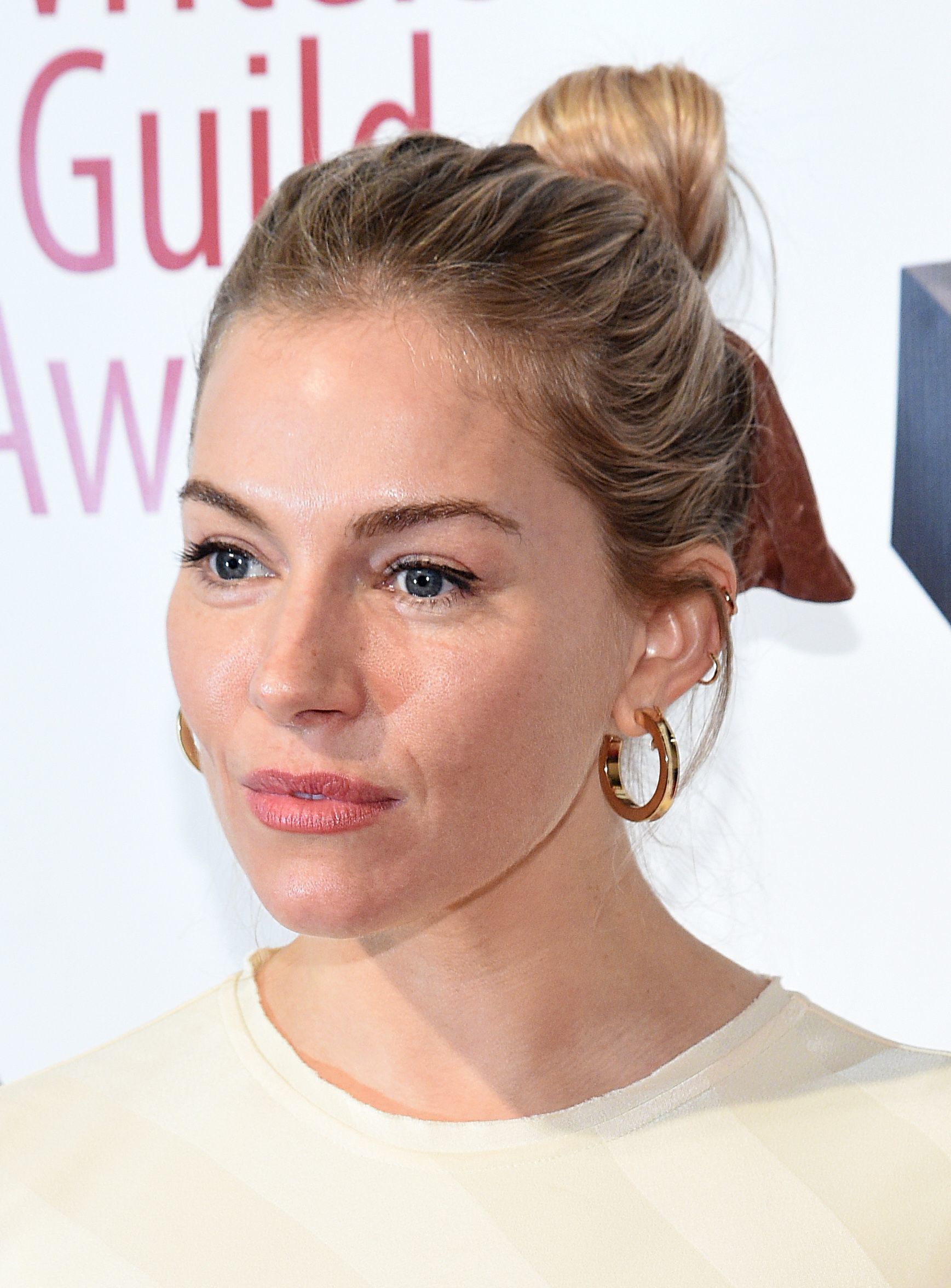 atriz sienna miller com cabelo preso para trás