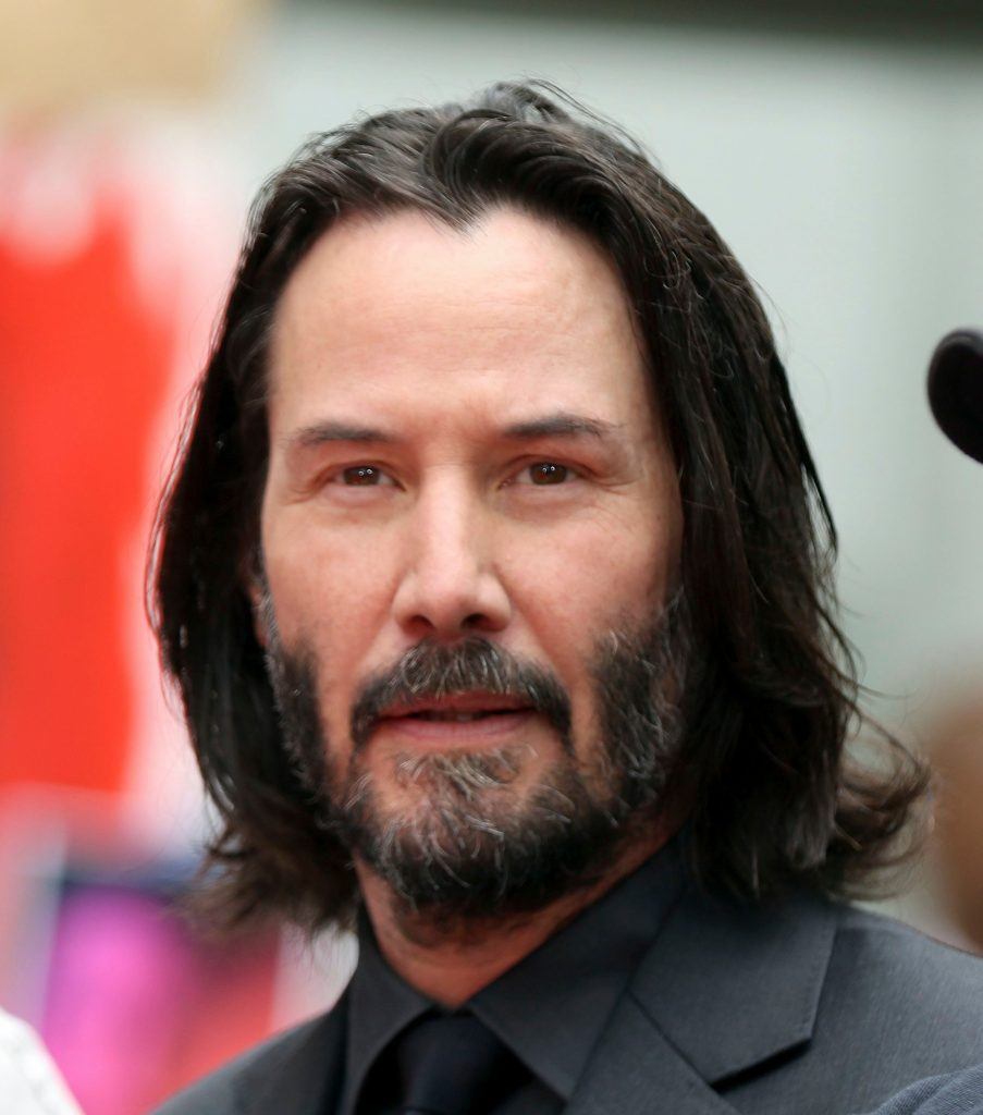 ator keanu reeves com cabelo médio dividido no meio