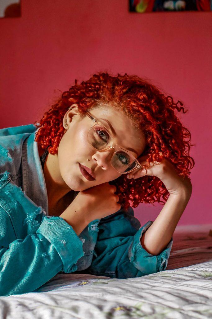 mulher com cabelo cacheado vermelho cereja