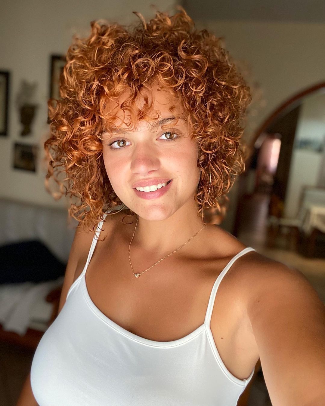 Mulher com cabelos cacheados acobreados
