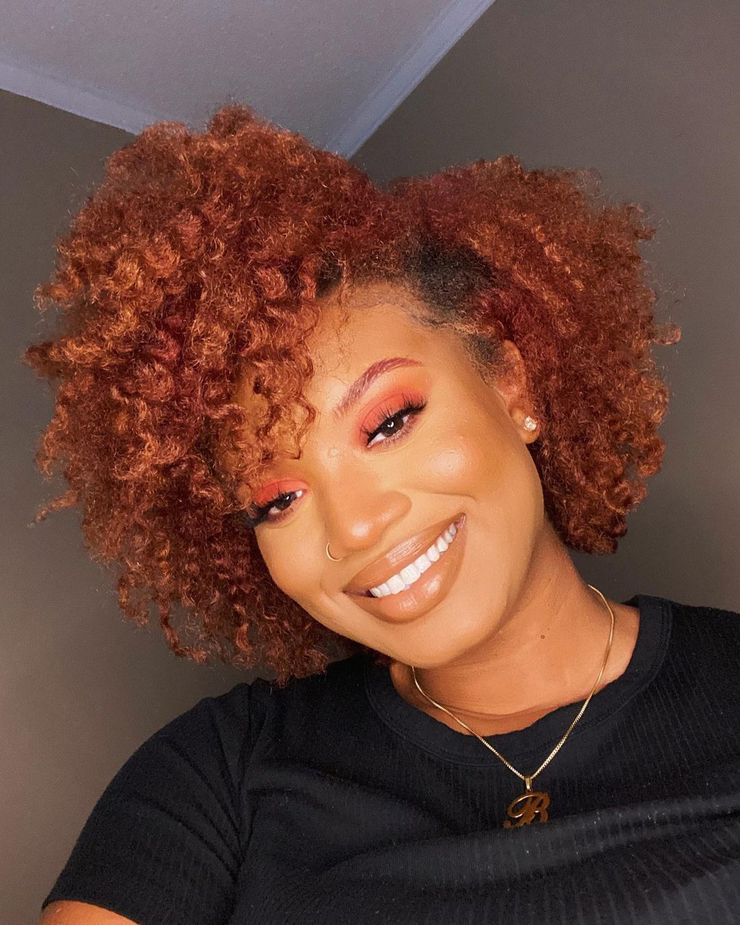 Mulher com cabelo cacheado vermelho acobreado