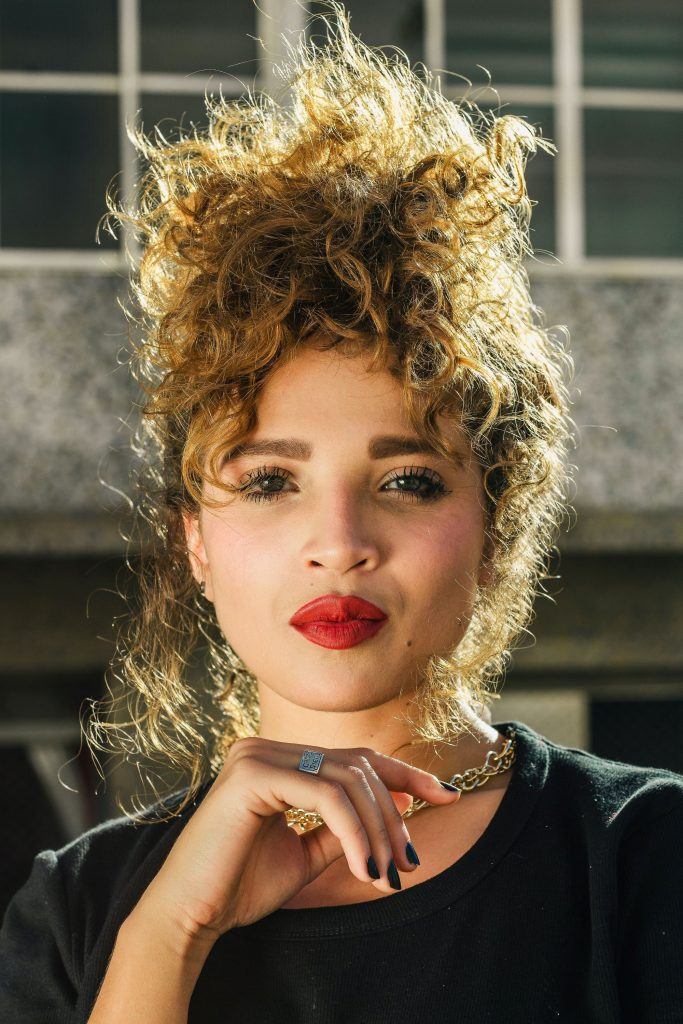 mulher com cabelo cacheado castanho claro