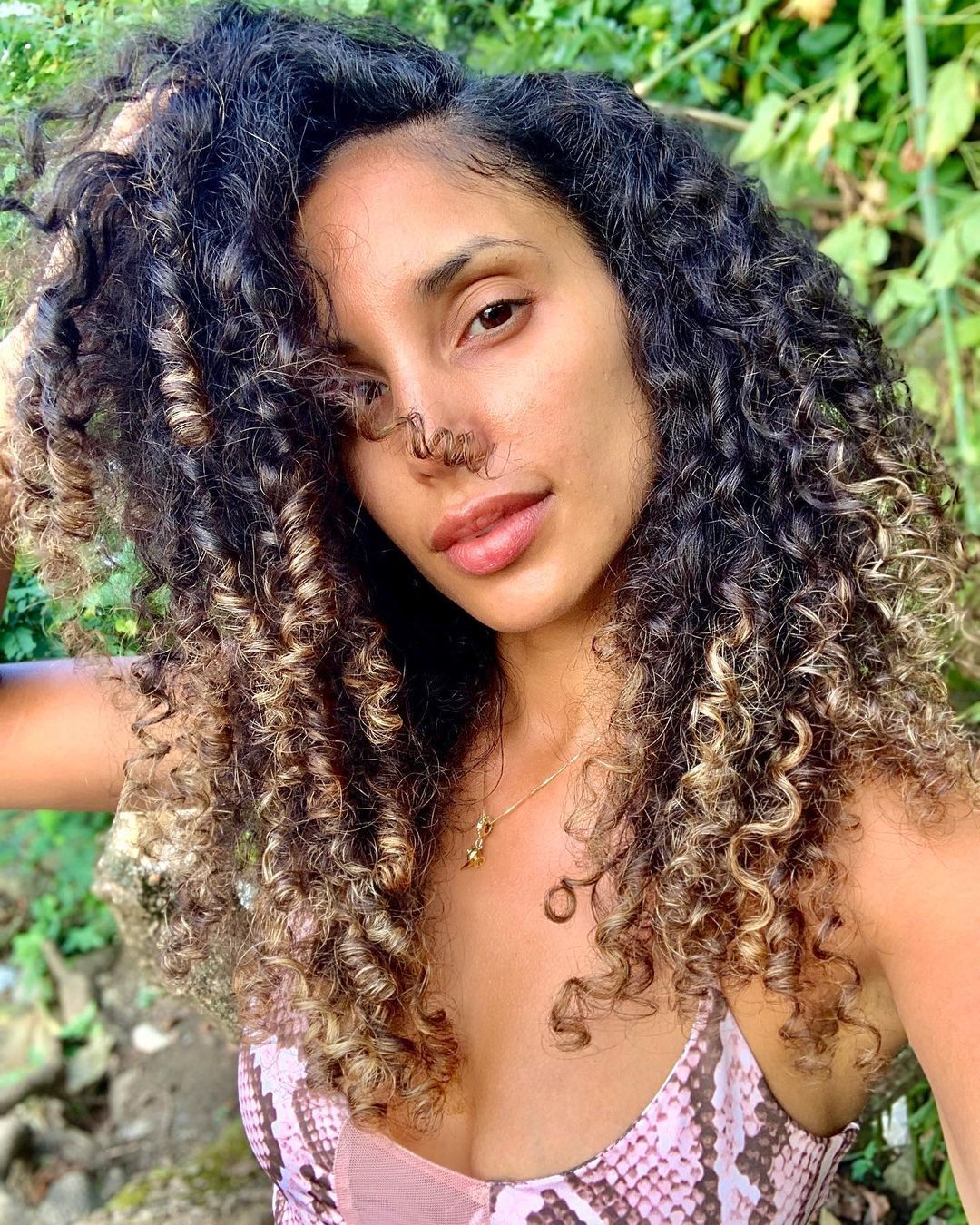 Mulher com mechas californianas no cabelo cacheado