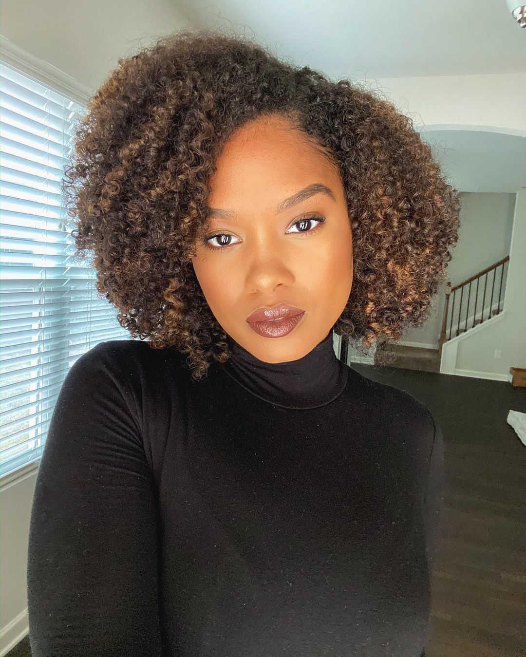 Mulher com mechas degradé no cabelo cacheado