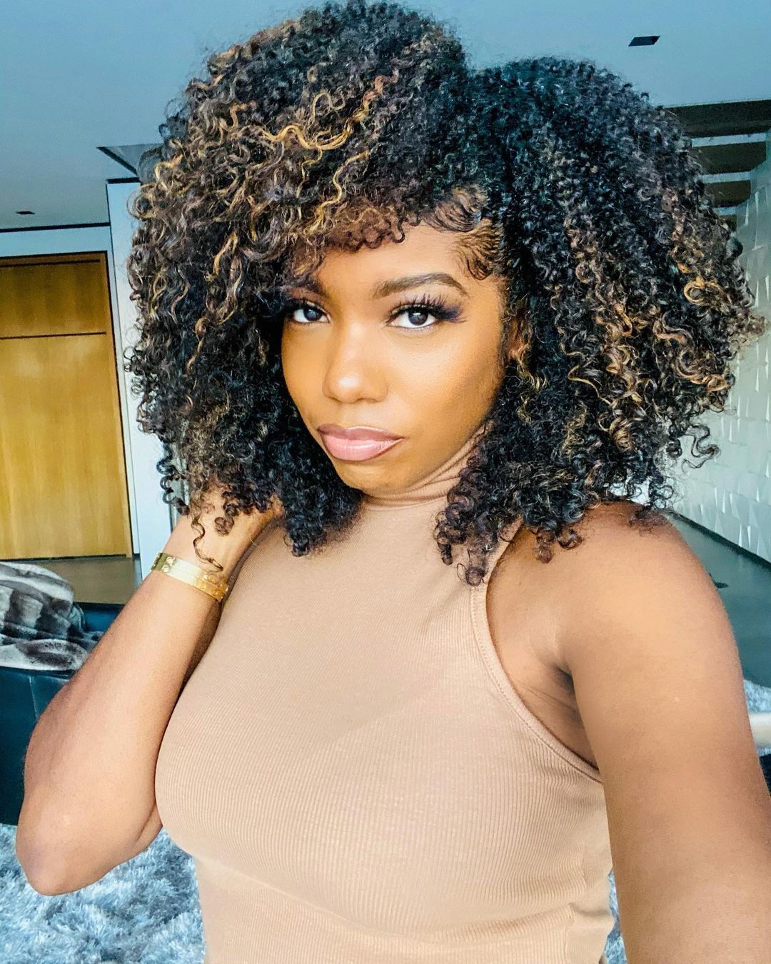 Mulher com mechas californianas no cabelo cacheado
