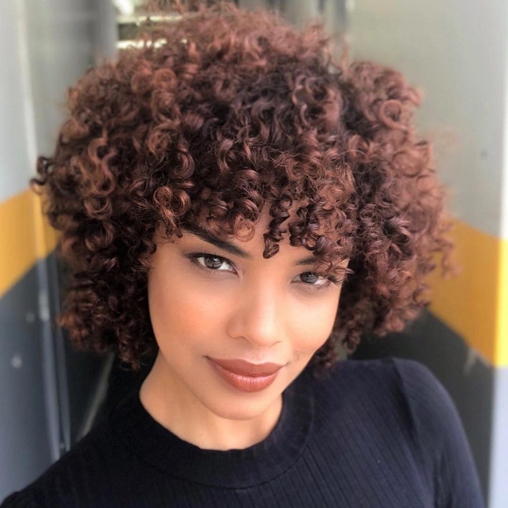 mulher com cabelo curto feminino cacheado com franja