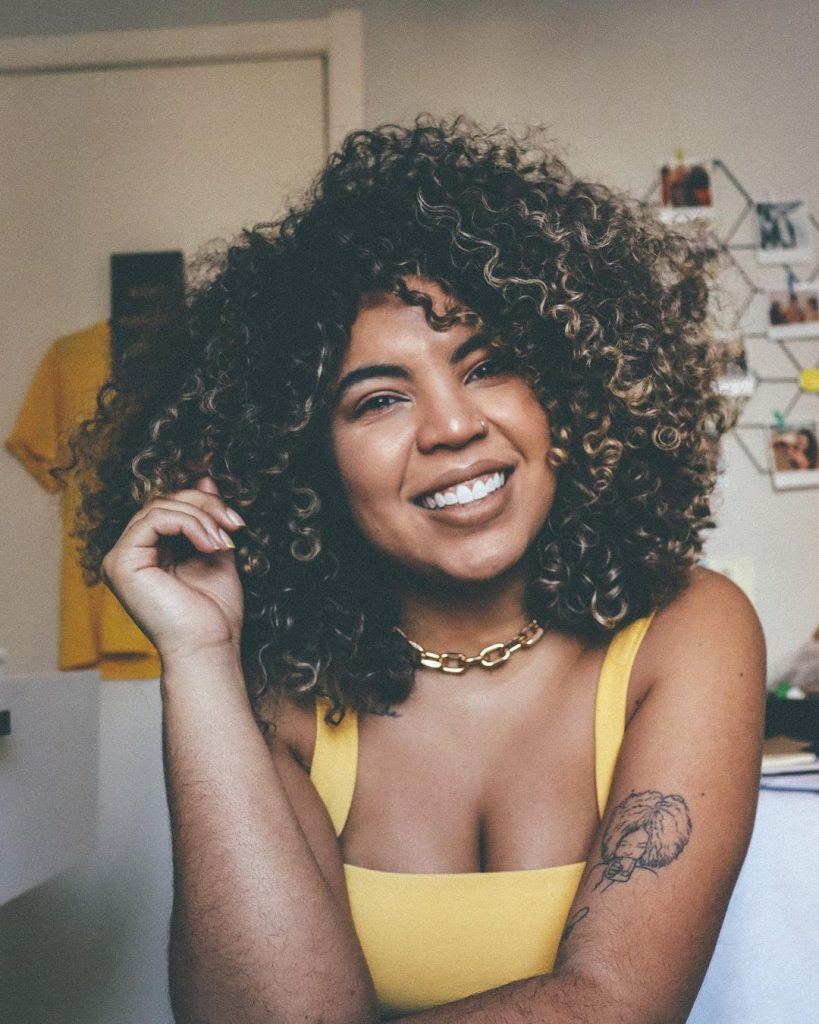 mulher de cabelo cacheado com corte para tirar volume