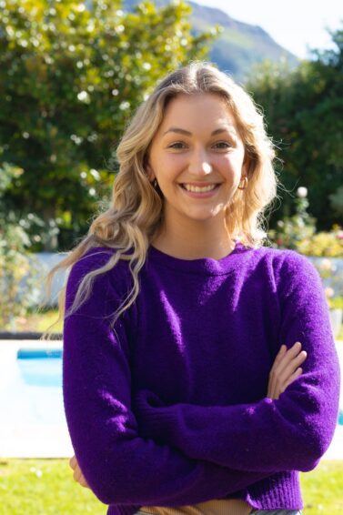 mulher loira em jardim sorrindo para a foto