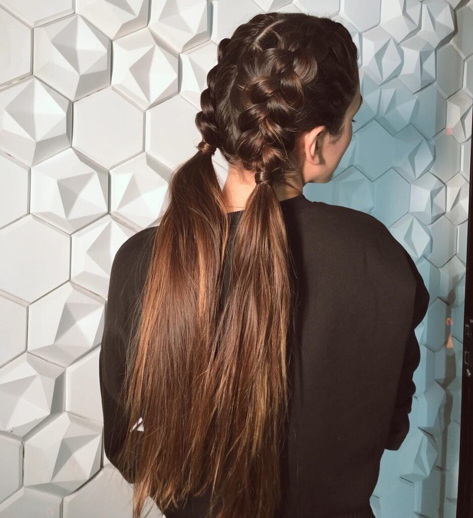 Penteado trança boxeadora dupla feito pela penteadista Gabriela Farah visto de costas em mulher de blusa preta e cabelo longo