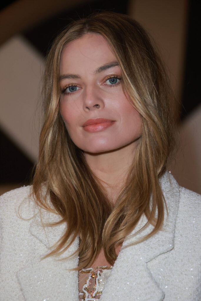 Atriz loira Margot Robbie com cabelo solto médio natural para rosto quadrado