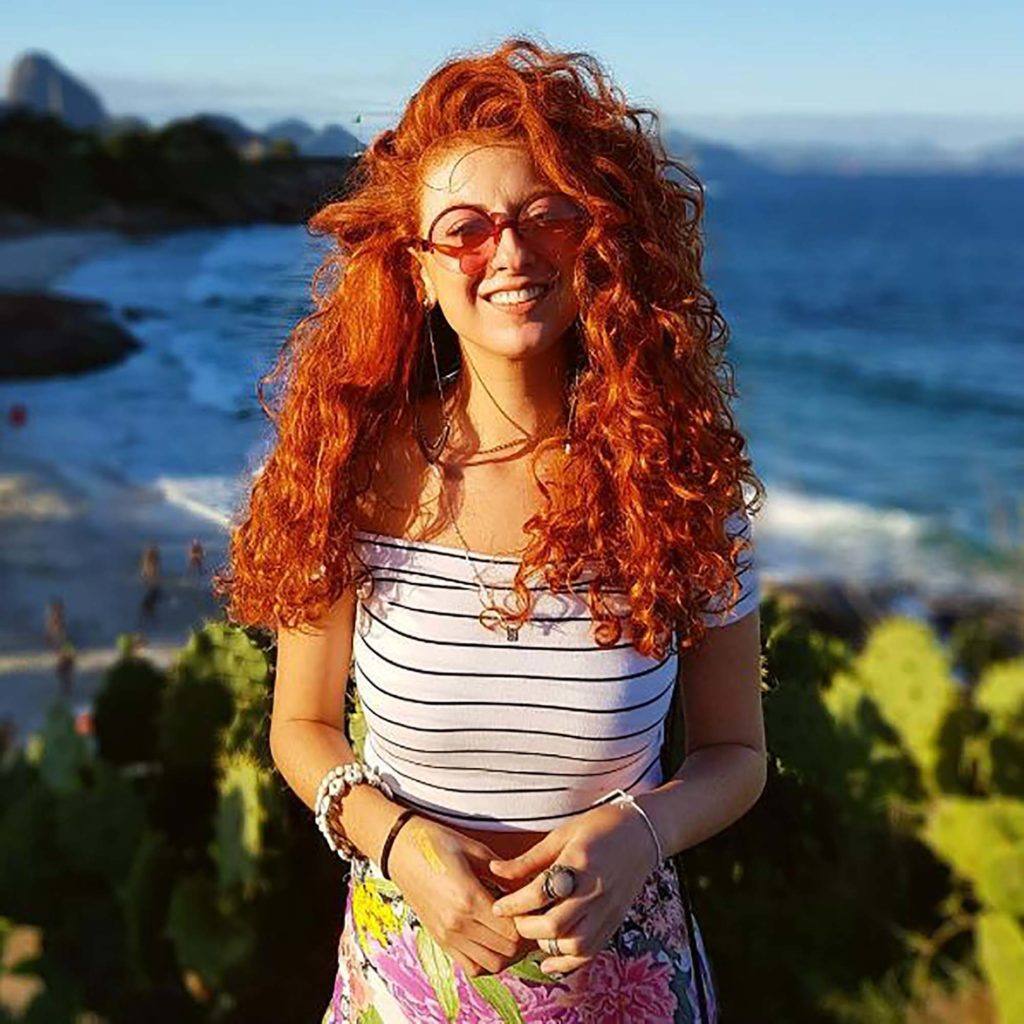 vitoria evangelista, influenciadora, com seu cabelo ruivo cacheado