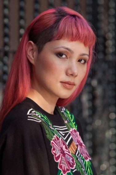 Mulher com cabelos sidecut cor-de-rosa