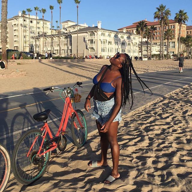 Mulher com tranças afro na praia