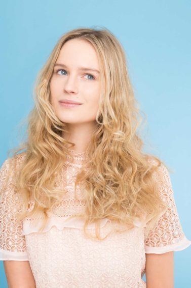 mulher loira usa ondas no cabelo e blusa branca