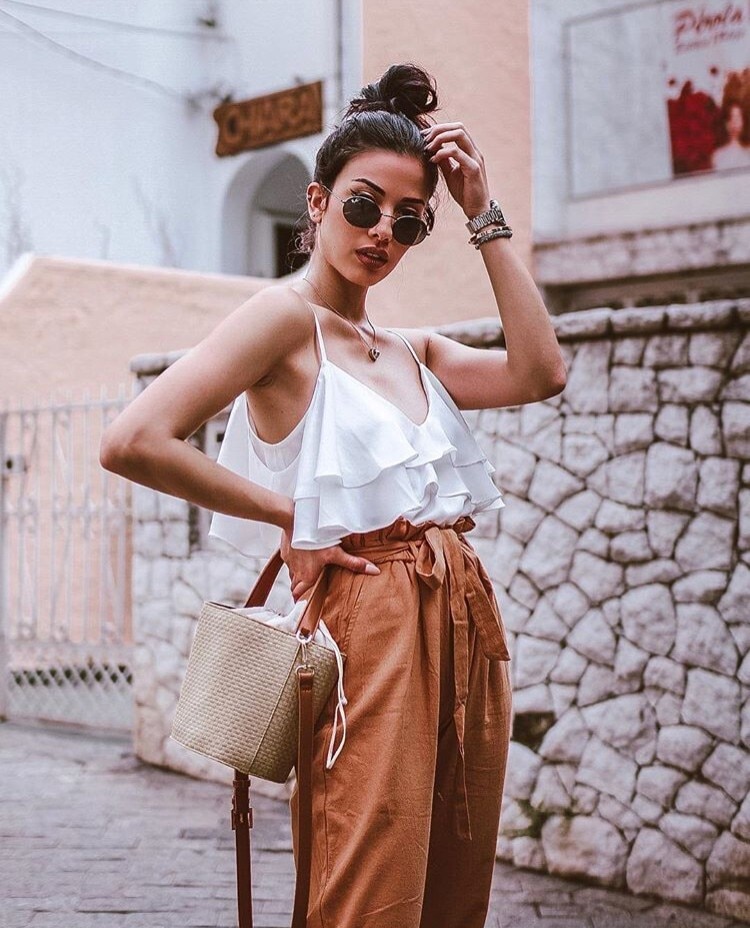 Influencer Thalita Ferraz com o cabelo preso em um coque alto