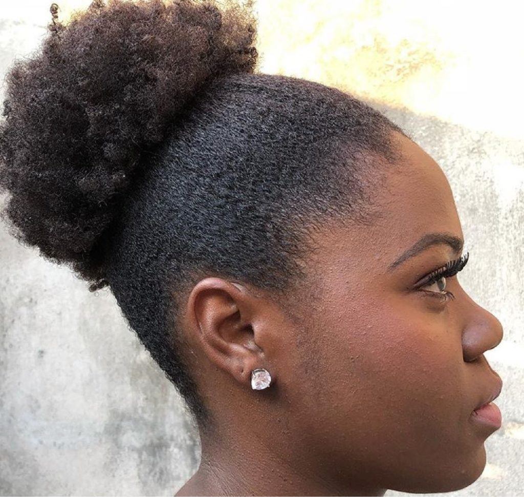 Mulher com coque no cabelo crespo