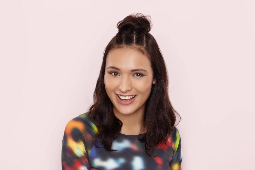 Mulher com cabelo semipreso, tranças e coque no topo da cabeça