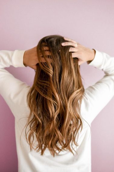 mulher de costas com cabelo castanho claro liso longo