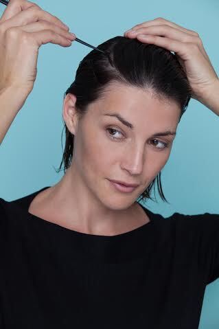 Mulher penteando os cabelos pretos curtos