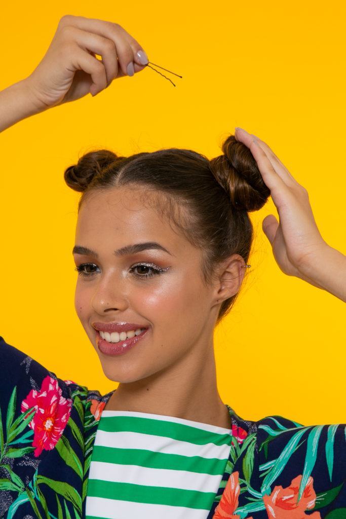 Modelo para penteado de space buns com glitter