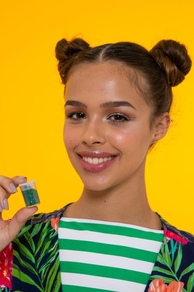 Modelo para penteado de space buns com glitter