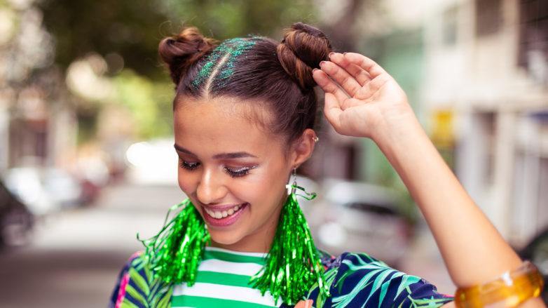 Modelo para penteado de space buns com glitter