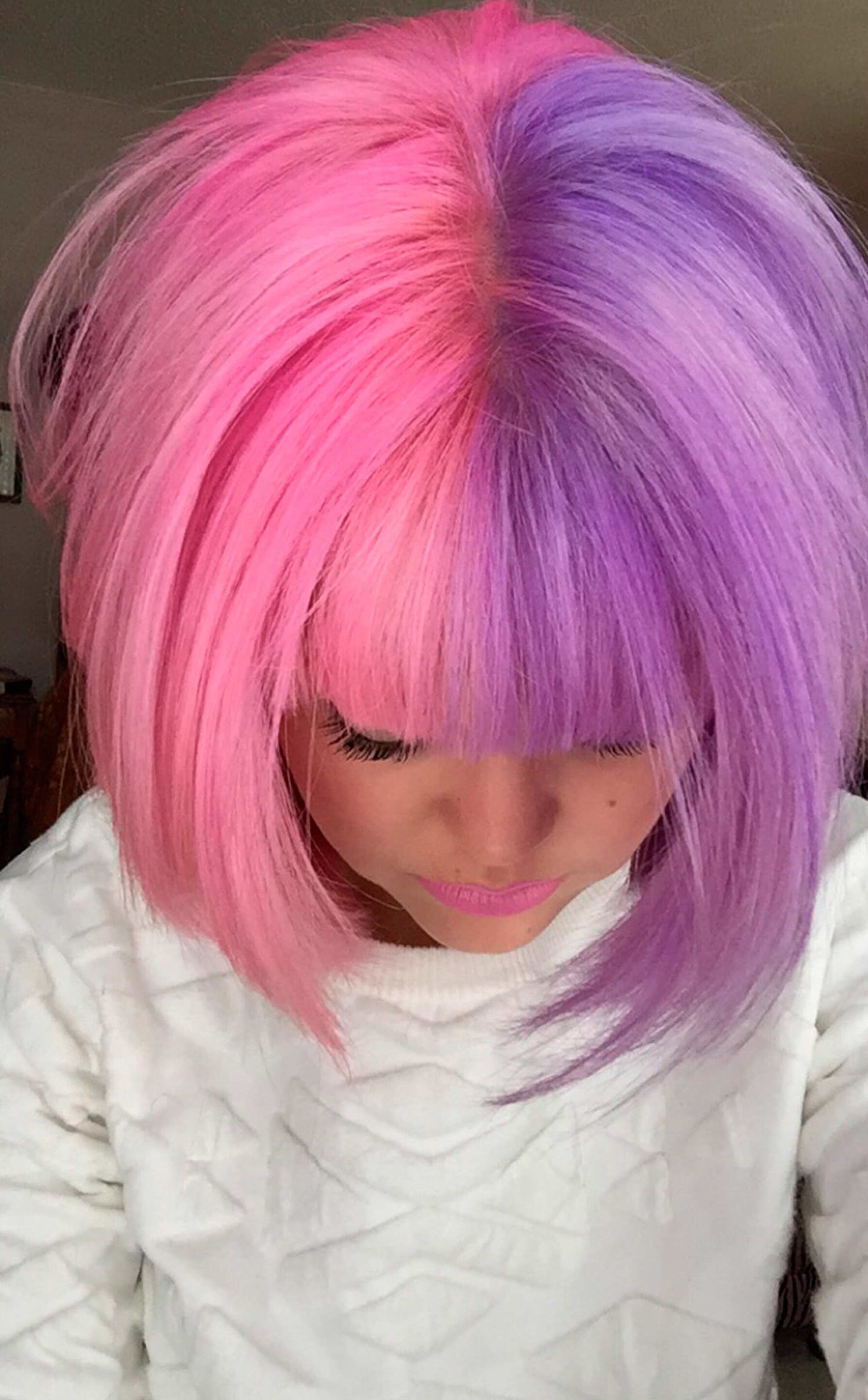 mulher com cabelo pintado com a tendência split hair com as cores rosa e roxo