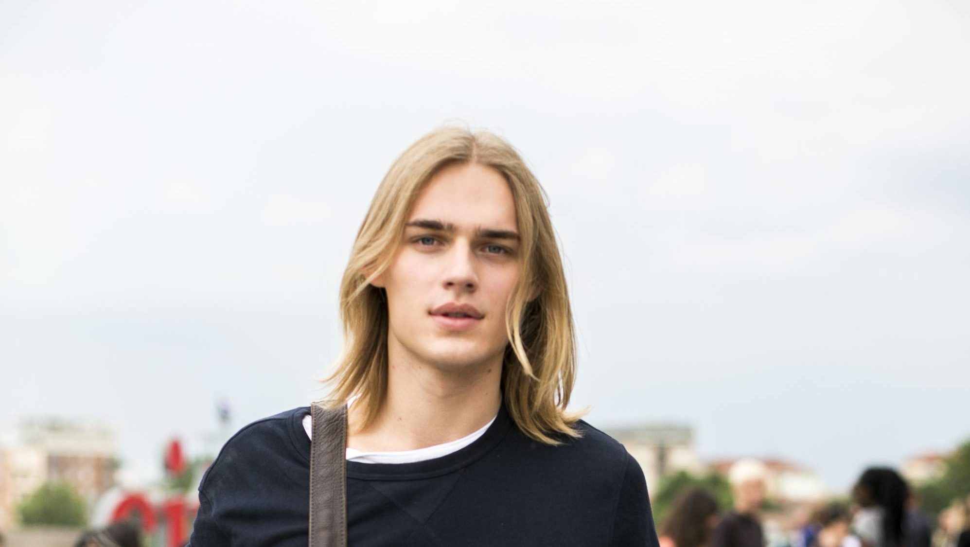 Homem usa cabelo loiro e longo, uma tendência de cabelo masculino 2017