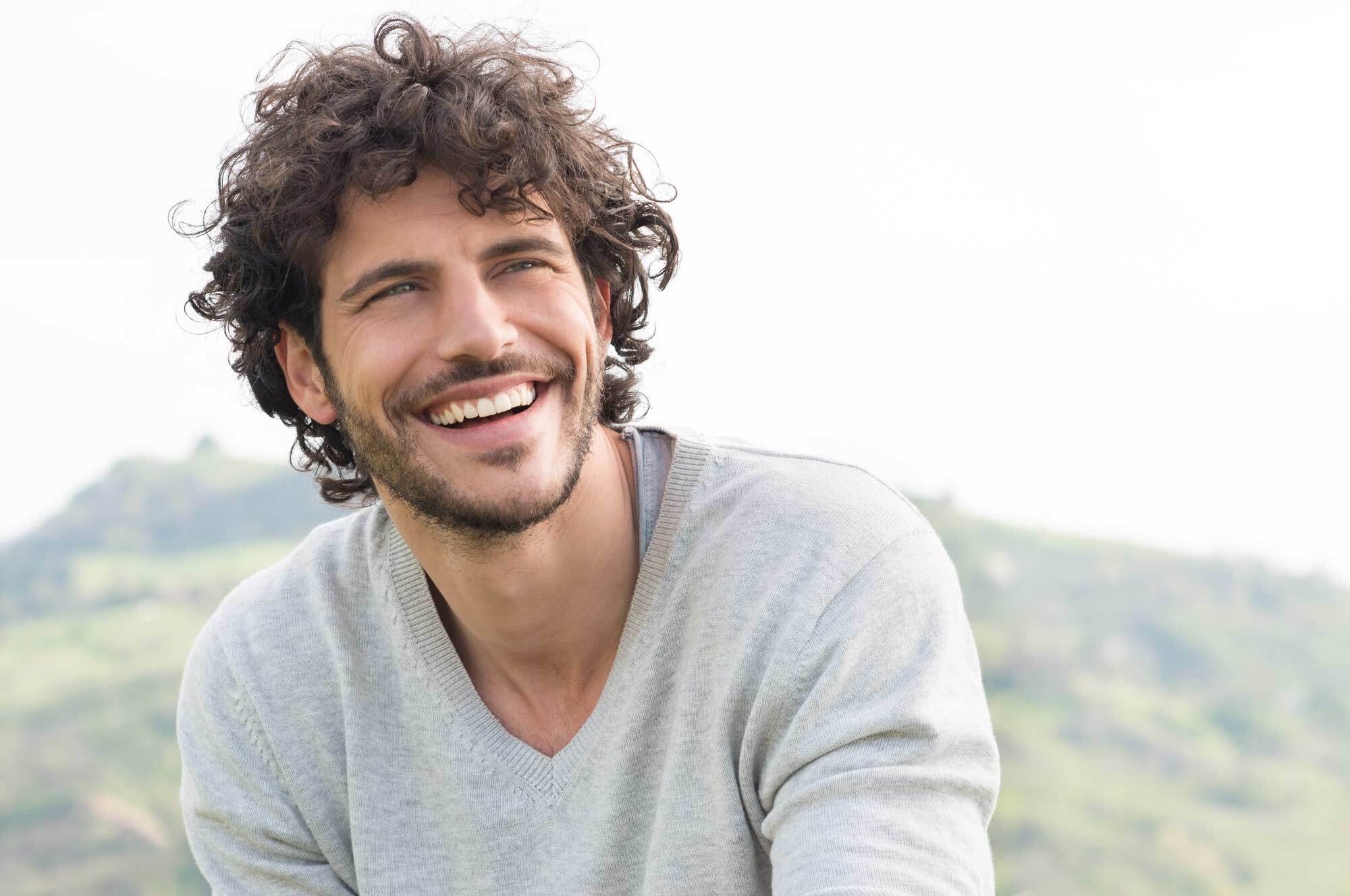 Homem usa cabelo castanho e cacheado, normcore é tendência de cabelo masculino 2017