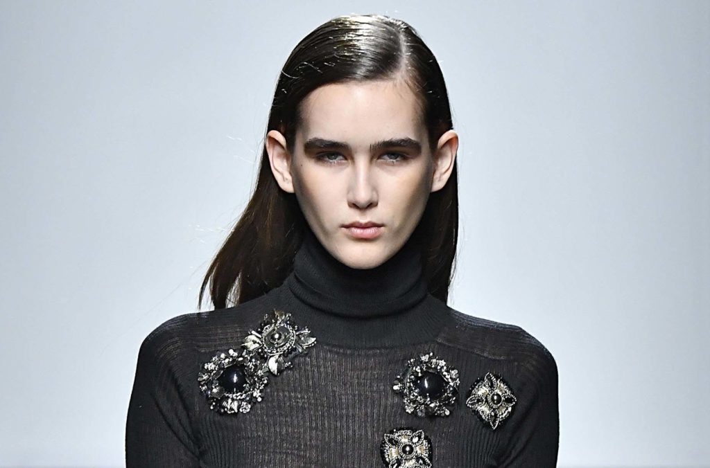 Modelo morena de cabelos lisos com risca lateral para matéria das tendências de cabelos da MFW 2017
