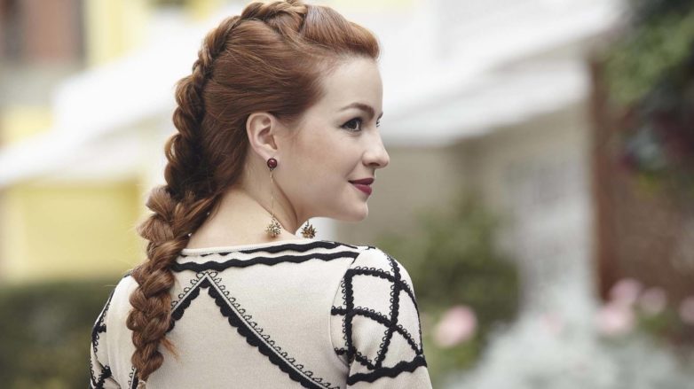 modelo com uma trança holandesa embutida no cabelo ruivo