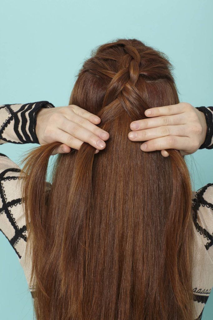 modelo com uma trança holandesa embutida no cabelo ruivo
