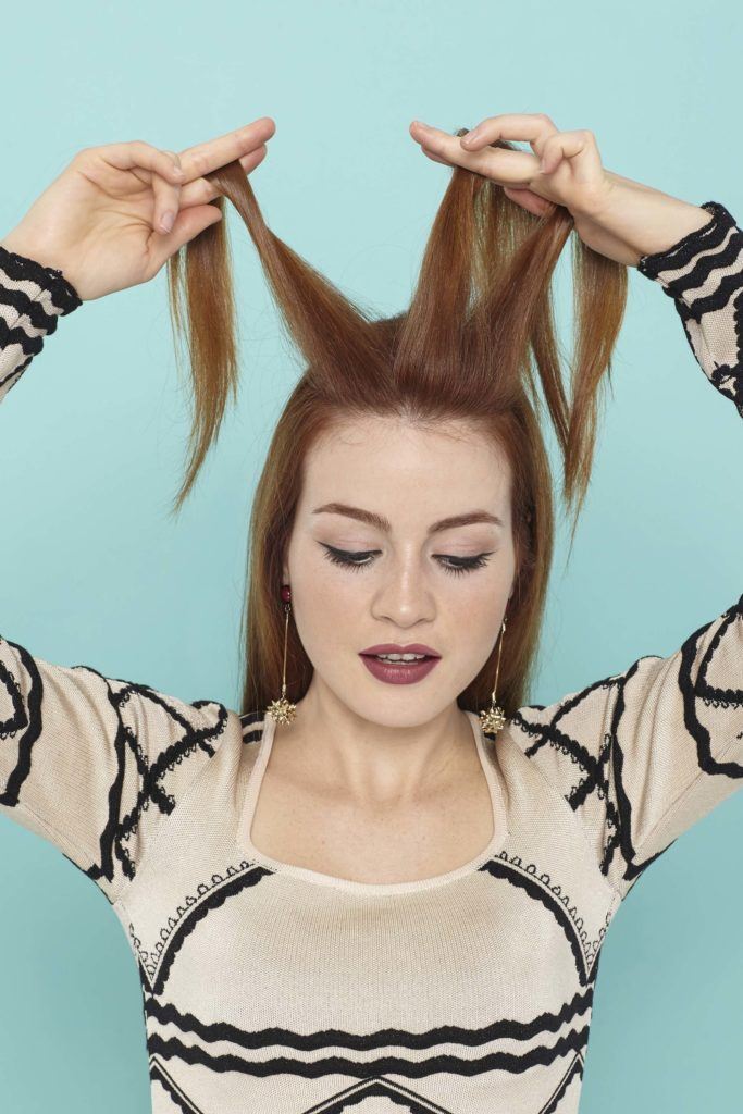 modelo com uma trança holandesa embutida no cabelo ruivo