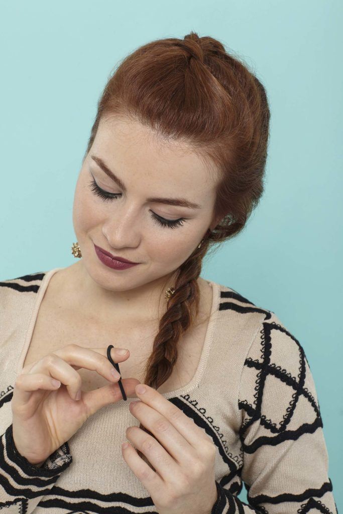 modelo com uma trança holandesa embutida no cabelo ruivo