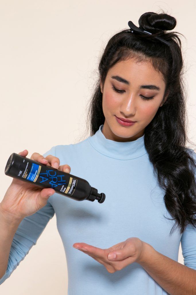 modelo com tranças no cabelo invertidas aplicando creme para pentear
