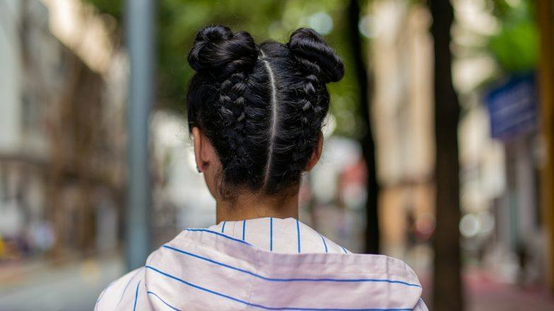 modelo com tranças de cabelo invertidas com coque duplo