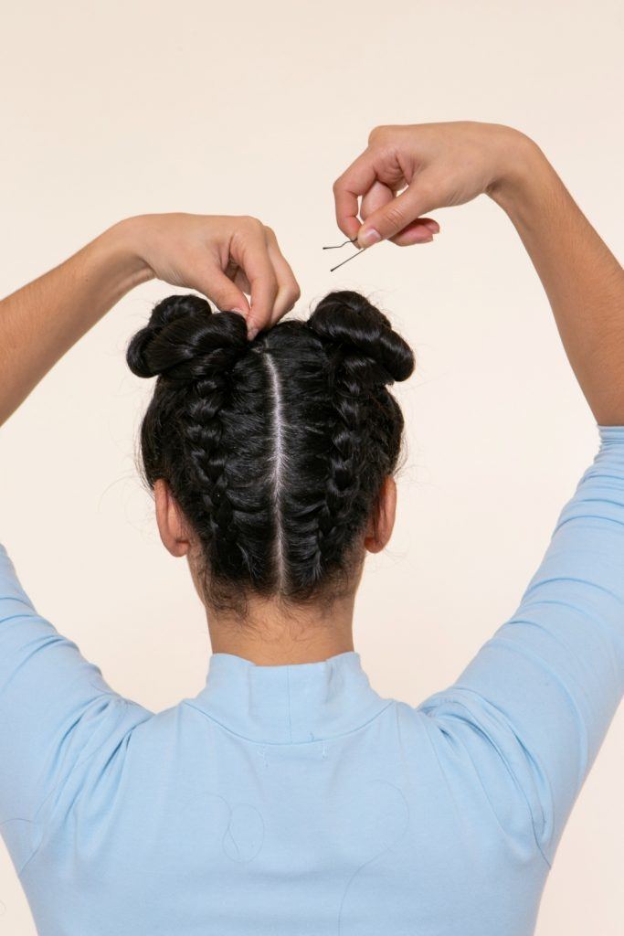 modelo com tranças no cabelo invertidas com coque duplo