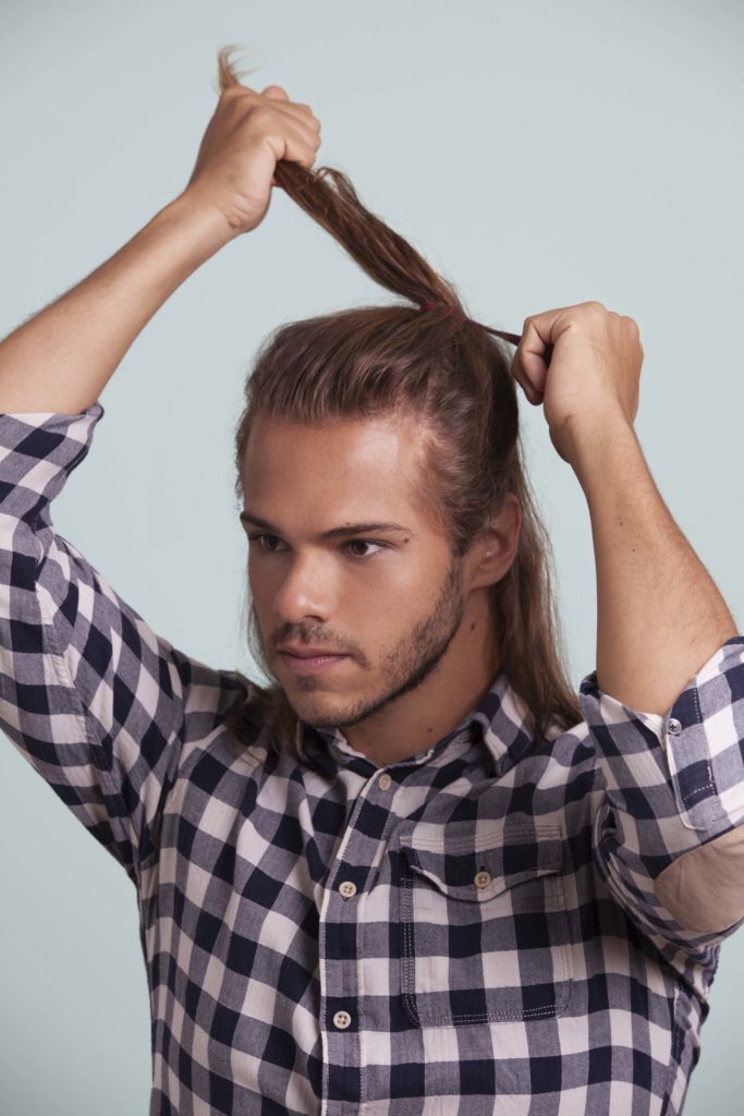 Modelo posa fazendo meio rabo, ou cabelo semi preso