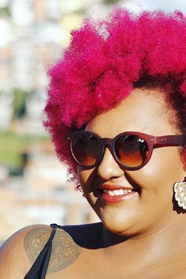 Mulher com cabelos afro curtos e cor-de-rosa
