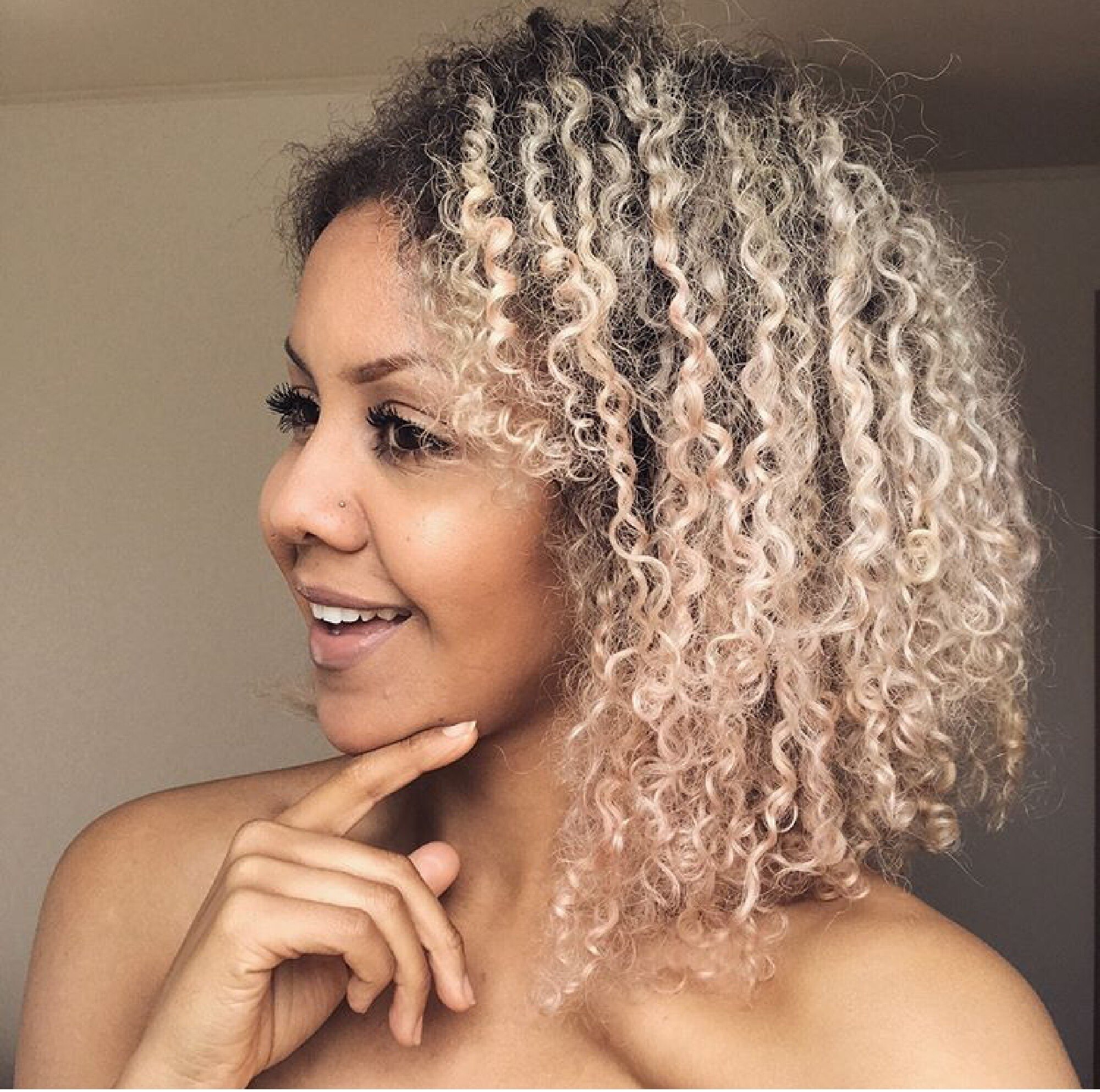 Mulher com cabelos afro e mechas loiras